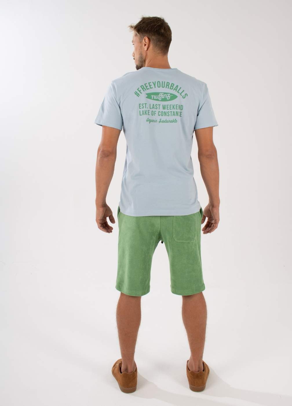 nuffinz STONE GREEN TOWEL SHORTS - whole outfit visible from the back - made out of organic terry cloth - sustainable men's shorts - green unicolor